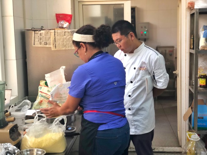 La sous chef Zobeira Gil enseñando al chef a preparar arepitas de maíz