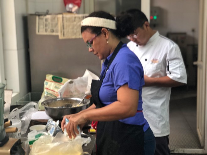 La sous chef Zobeira Gil enseñando al chef a preparar arepitas de maíz